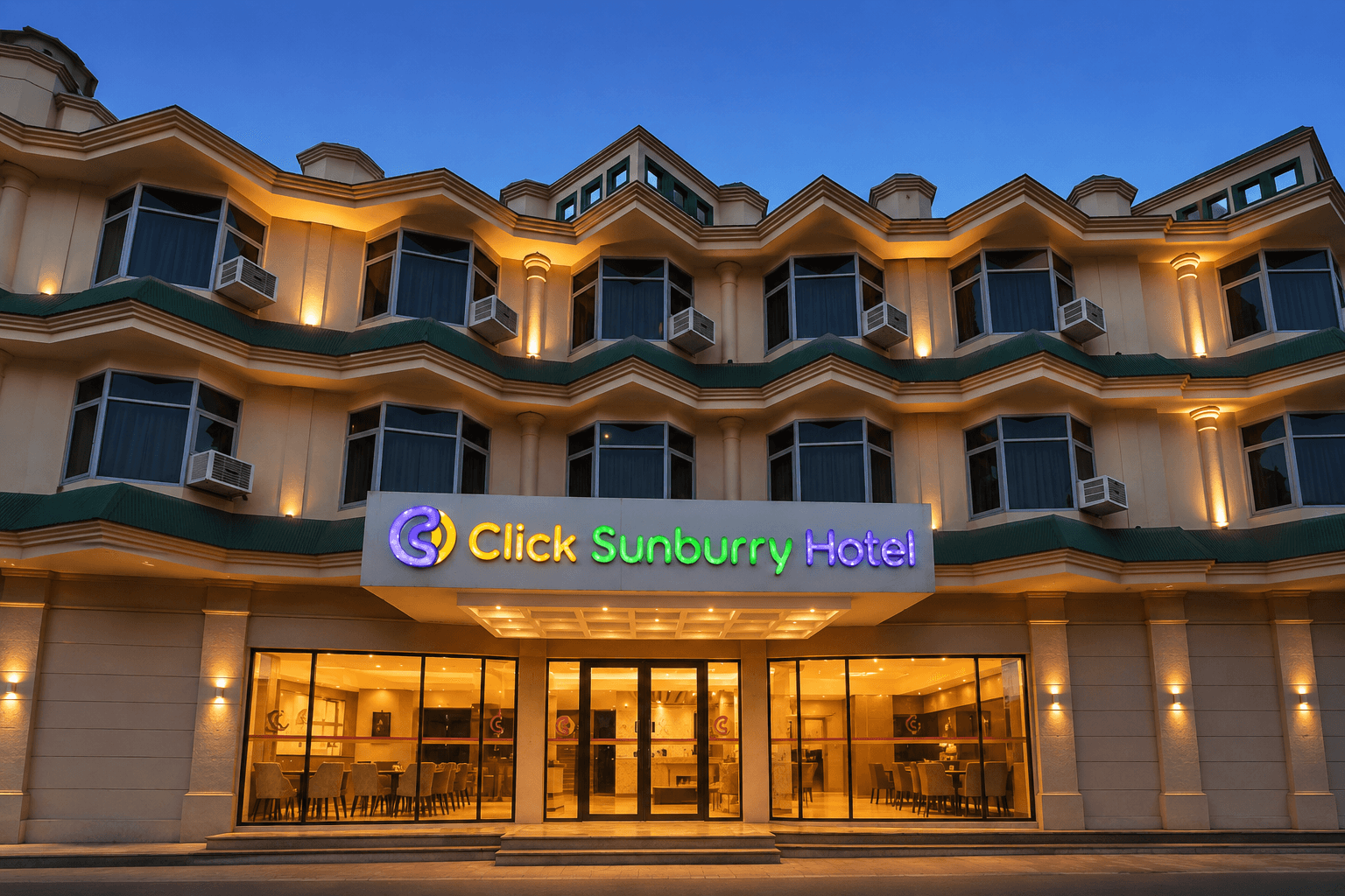 Front entrance of Click Sunburry Hotel illuminated at dusk